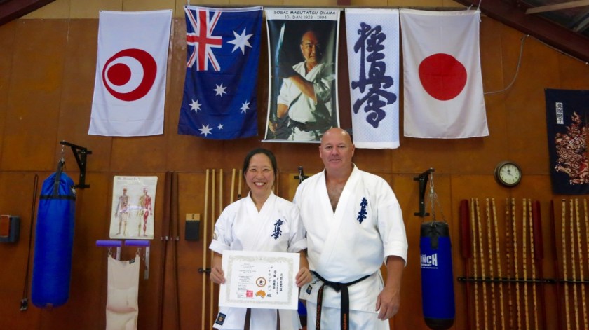 Trish Tan receives her 3rd Kyu in Kobudo from Shihan Rick Cunningham.